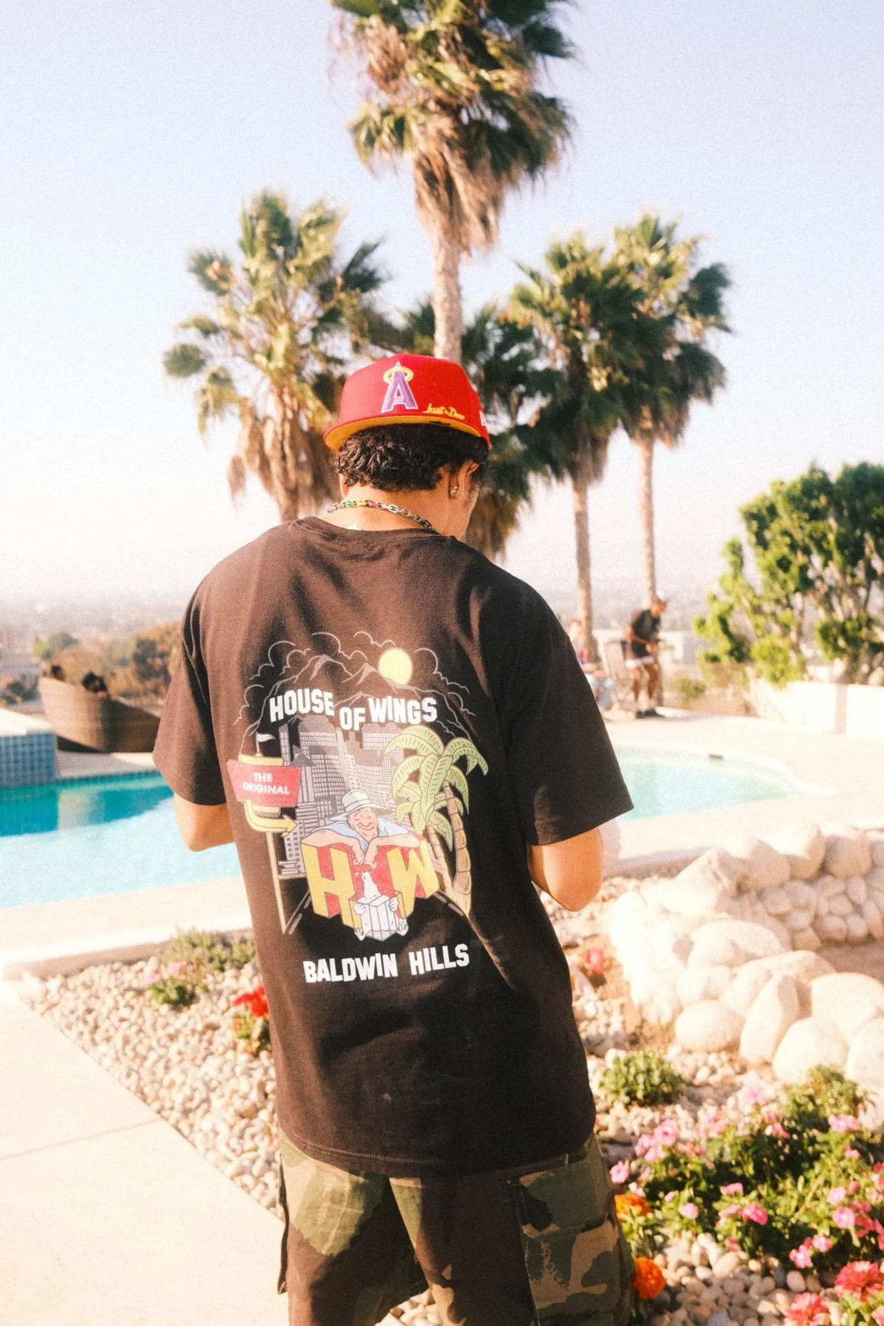 Baldwin Hills tee worn at a rooftop. The location specific back print puts the identity on a person rather than a vehicle.