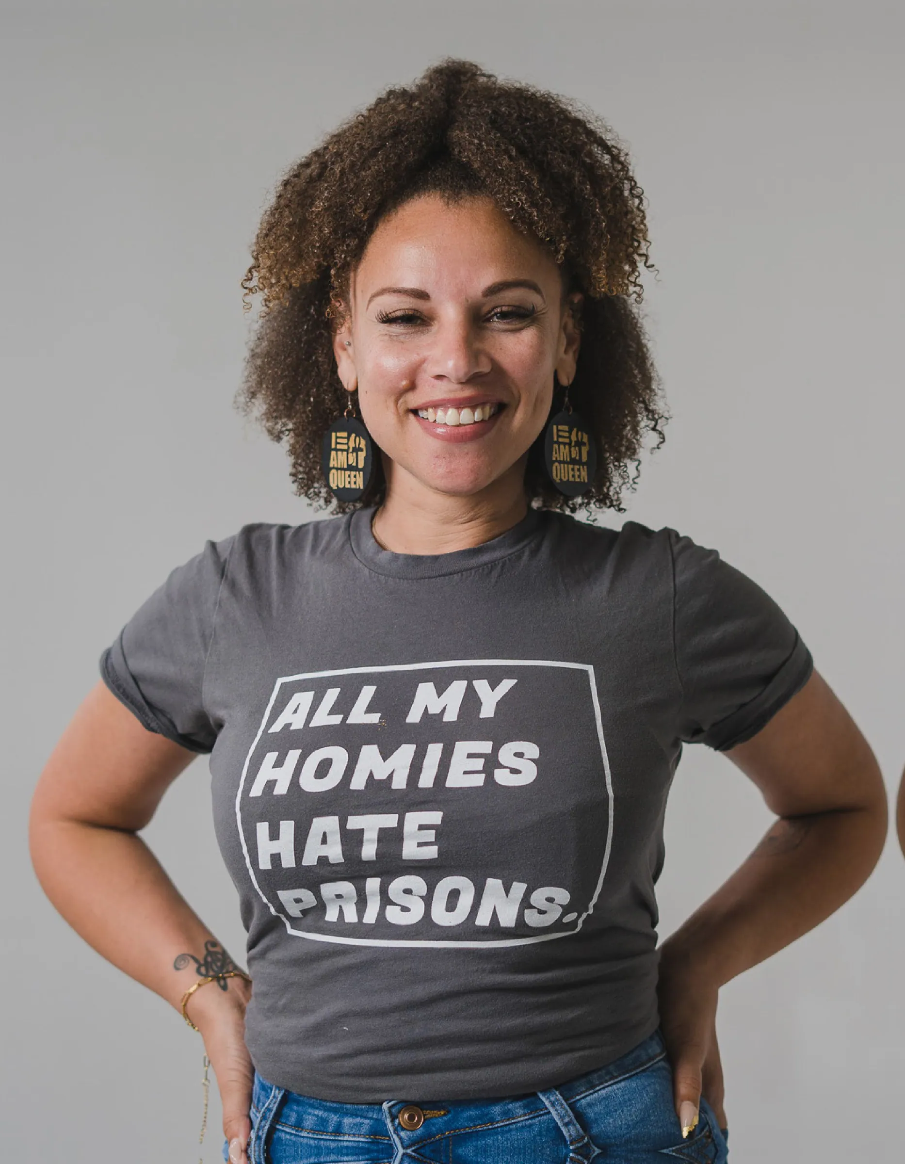 Portrait of an organizer in a tee reading All My Homies Hate Prisons, smiling at the camera.